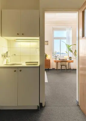 a kitchen with white cabinets and a dining room at Muze Suites in Prague