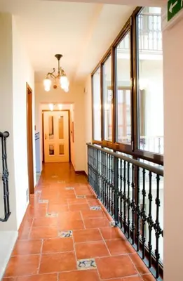 a hallway with a brick floor and windows at Prague Mystique Apartment in Prague