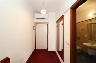 a hallway with a bathroom with a sink and a toilet at Prague Mystique Apartment in Prague