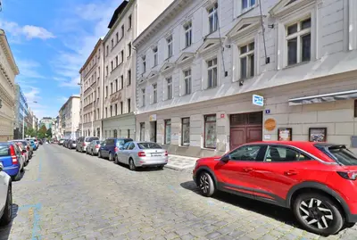 a red car parked on the side of a street at Prague Mystique Apartment in Prague