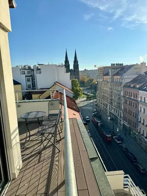 a balcony with a table and a view of a city at Luxury Penthouse - Castle View, Terrace, Center in Prague