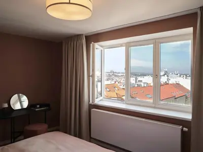 a bedroom with a window with a view of a city at Luxury Penthouse - Castle View, Terrace, Center in Prague