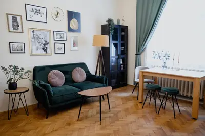 a living room with a green couch and stools at Old town apartment Kaprova in Prague