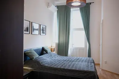 a bedroom with a bed and a large window at Old town apartment Kaprova in Prague
