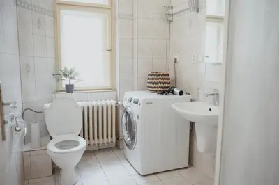 a bathroom with a washing machine and a sink at Old town apartment Kaprova in Prague