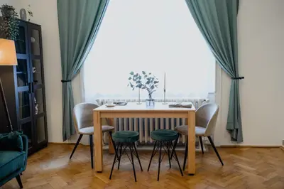 a dining room table and chairs with a window at Old town apartment Kaprova in Prague