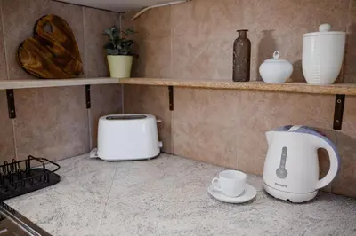 a kitchen counter with a toaster and cups and shelves at Old town apartment Kaprova in Prague