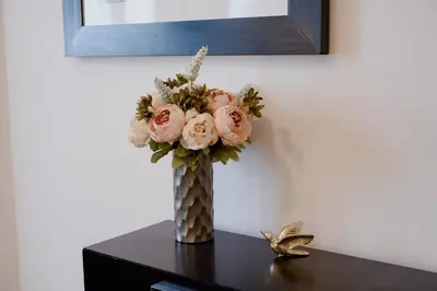 a vase filled with pink roses on a table at Old town apartment Kaprova in Prague