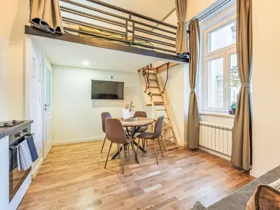 a room with a table and chairs and a loft bed at Apartment Washington-5 by Interhome in Prague