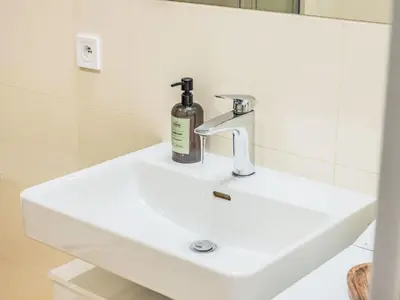 a white bathroom sink with a bottle of soap on it at Apartment Washington-5 by Interhome in Prague