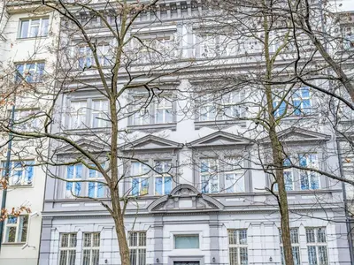 a white building with trees in front of it at Apartment Čelakovsky-4 by Interhome in Prague