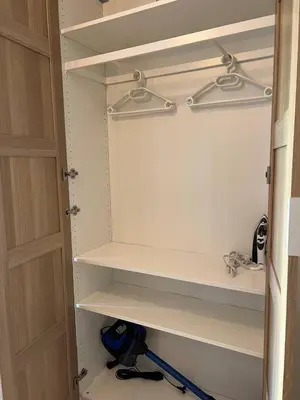 a closet with white shelves and a door at Urban Nest On Tyrsova 7 - Near IP Pavlova Metro in Prague
