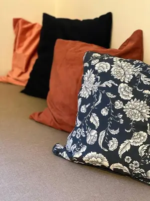 a blue and white pillow sitting on the floor next to some pillows at Urban Nest On Tyrsova 7 - Near IP Pavlova Metro in Prague