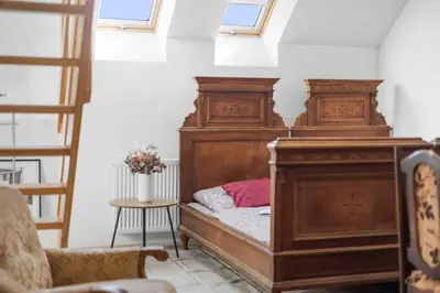 a bedroom with a bed with a wooden headboard at Statek Luigi in Tuchlovice