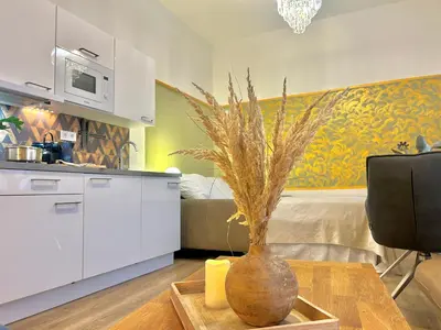 a living room with a table with a vase on a table at Homely Nook Prague Centre in Prague