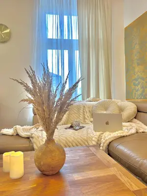 a living room with a couch and a table with a laptop at Homely Nook Prague Centre in Prague