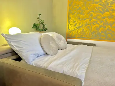 a bed with white pillows and a painting on the wall at Homely Nook Prague Centre in Prague