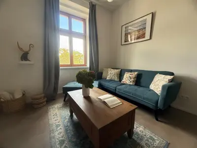 a living room with a blue couch and a coffee table at One-bedroom newly renovated apartment with Netflix in Prague