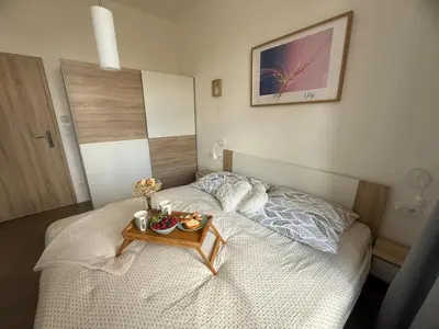 a small bed with a tray of food on it at One-bedroom newly renovated apartment with Netflix in Prague
