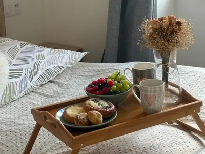 a tray with a plate of food on a bed at One-bedroom newly renovated apartment with Netflix in Prague