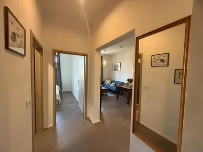 a hallway with a mirror and a living room at One-bedroom newly renovated apartment with Netflix in Prague