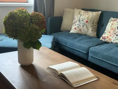 a vase of flowers sitting on a table with a book at One-bedroom newly renovated apartment with Netflix in Prague