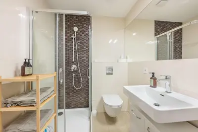 a white bathroom with a sink and a shower at HOMELY I Central 52m2 APT I ELEVATOR I Self Check-In in Prague
