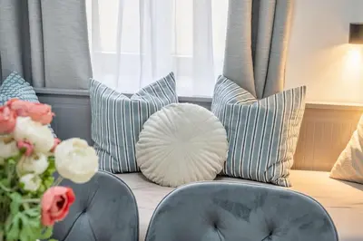 a couch with pillows and a vase of flowers at HOMELY I Central 52m2 APT I ELEVATOR I Self Check-In in Prague