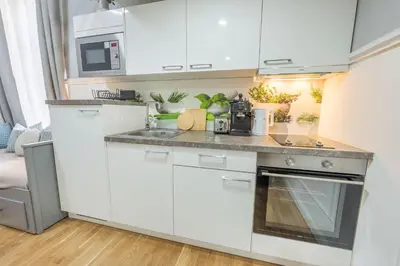 a kitchen with white cabinets and a sink at HOMELY I Central 52m2 APT I ELEVATOR I Self Check-In in Prague