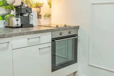 a kitchen with white cabinets and a black oven at HOMELY I Central 52m2 APT I ELEVATOR I Self Check-In in Prague