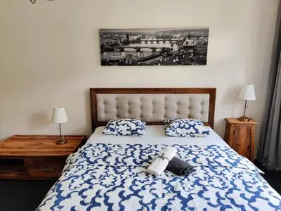 a bedroom with a bed with blue and white sheets and pillows at Zizkov Stay - Near City Center in Prague