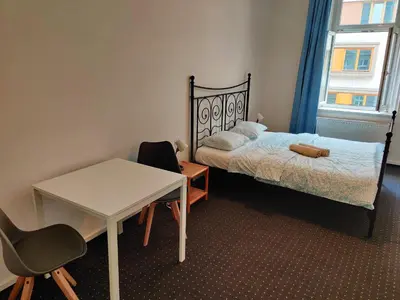 a bedroom with a bed and a table and a desk at Zizkov Stay - Near City Center in Prague