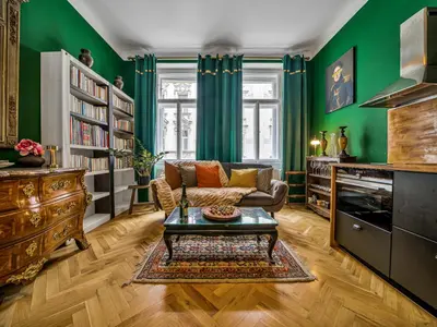 a living room with green walls and a couch and a table at Spacious 85 sqm Apartment for Monthly Stays in Prague