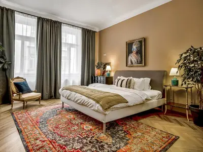 a bedroom with a large bed and a rug at Spacious 85 sqm Apartment for Monthly Stays in Prague