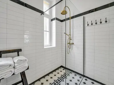 a bathroom with a shower with white tiles at Spacious 85 sqm Apartment for Monthly Stays in Prague