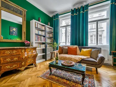 a living room with green walls and a couch and a table at Spacious 85 sqm Apartment for Monthly Stays in Prague
