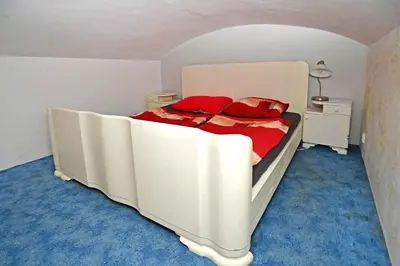 a white bed with red pillows in a bedroom at Cozy Apartment in Letná in Prague