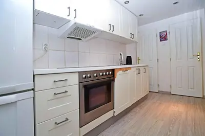 a kitchen with white cabinets and a stove top oven at Cozy Apartment in Letná in Prague