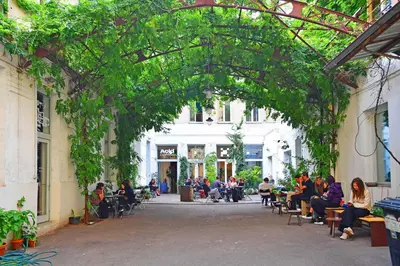 a group of people sitting on benches in an alley at Cozy Apartment in Letná in Prague