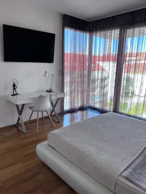 a bedroom with a bed and a desk and a television at Room Korunní dvur in Prague