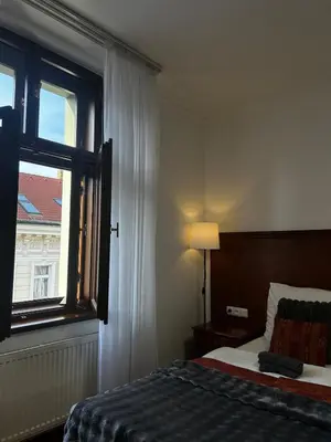 a bedroom with a bed and a window at Vintage Apartment Old Prague Charm in Prague