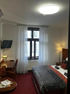 a hotel room with a bed and a desk and a window at Vintage Apartment Old Prague Charm in Prague