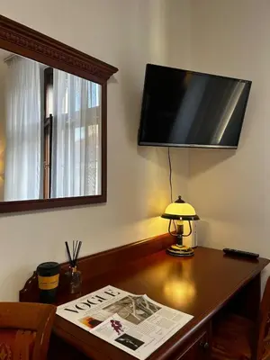 a desk with a television on a wall with a lamp at Vintage Apartment Old Prague Charm in Prague