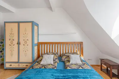 a bedroom with a bed with blue sheets and a table at Royal Prague Gallery in Prague