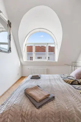a bedroom with a large bed with an arched window at Royal Prague Gallery in Prague