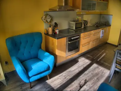 a kitchen with a blue chair and a microwave at Stela's Apartments - Vysehrad in Prague