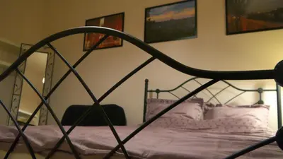 a bedroom with a metal bed with purple sheets at Stela's Apartments - Vysehrad in Prague