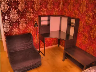 a desk and chair in a room with a red wall at Stela's Apartments - Vysehrad in Prague