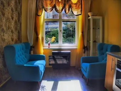 a living room with two blue chairs and a window at Stela's Apartments - Vysehrad in Prague