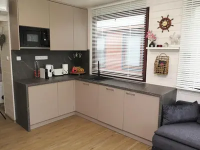 a kitchen with white cabinets and a black counter top at Houseboat Rosie in Prague